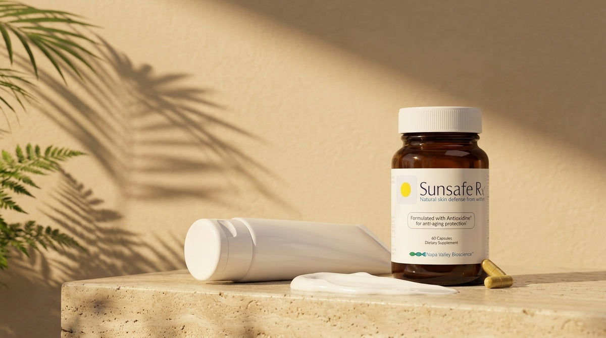 An unbranded white sunscreen tube and a smear of lotion on a stone ledge in golden light, a Sunsafe Rx bottle beside it