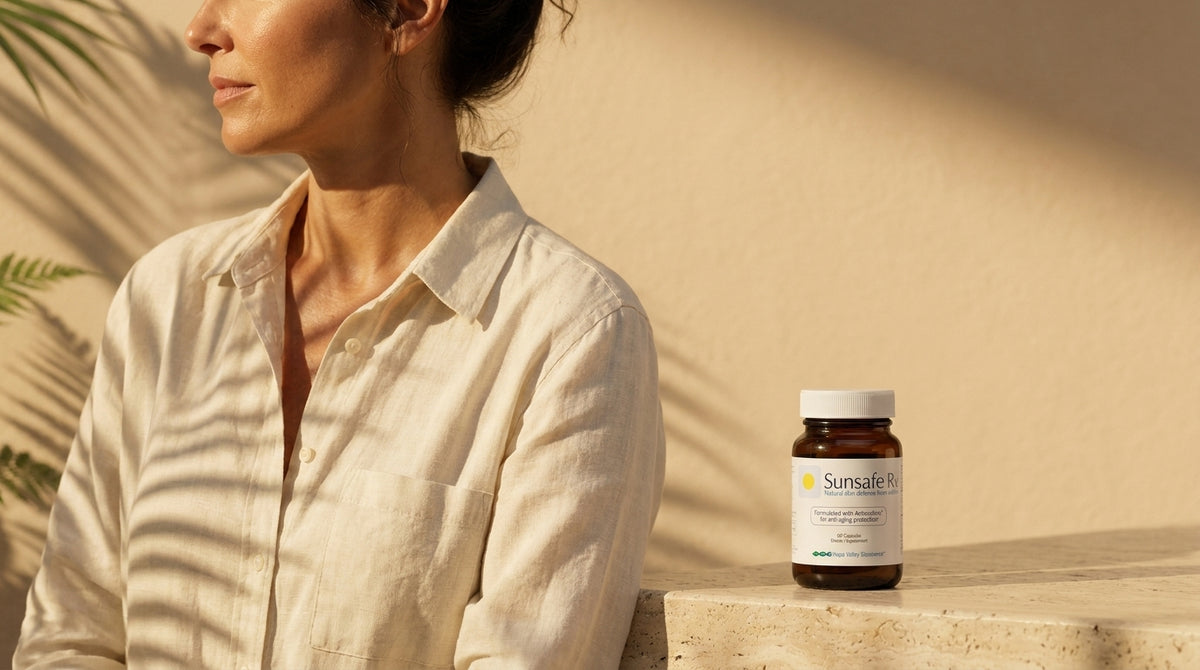A woman's shoulder and profile in low golden light with palm-leaf shadows, a Sunsafe Rx bottle on the stone ledge